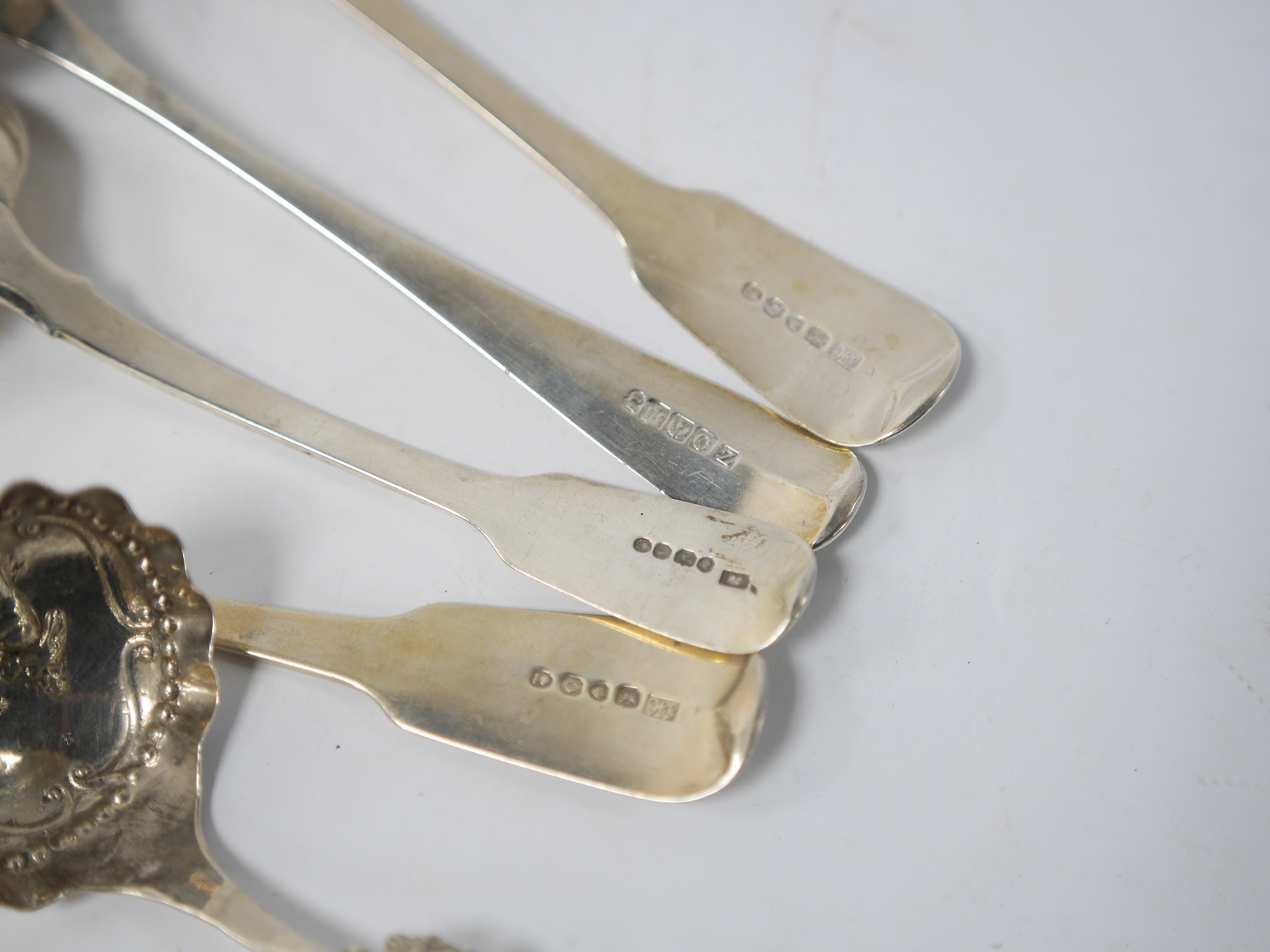 A late 19th century continental silver caddy spoon, with figural terminal, import marks for Sheffield, 1894, together with four assorted 19th century spoons including three table spoons and a sauce ladle, various dates a